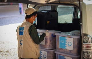 a volunteer loads a car with supplies in Yemen