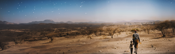 Image of a pastoral farmer walking amongst a dry and arid landscape.