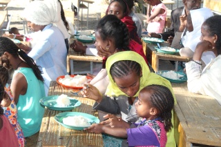 people sitting at a table with plates of food before them