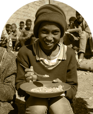 A child in Ethiopia sits down to eat at school