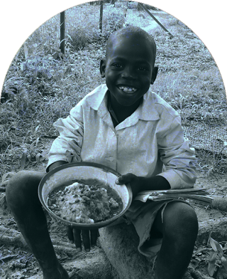 A child in South Sudan sits down to eat at school