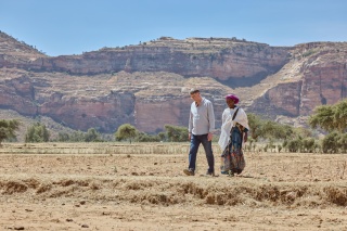 a man and woman walking in harsh looking desert climate