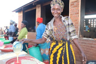 Nizigiyimana serving food at the school she volunteers at. 