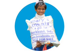 A girl in India with food from Mary's Meals