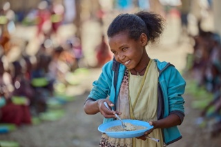 A young girl eating her lunch at Tsehafe Werdi Primary school, Tigray Ethiopia 